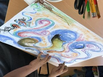 A story-maker uses pastels to make a drawing
